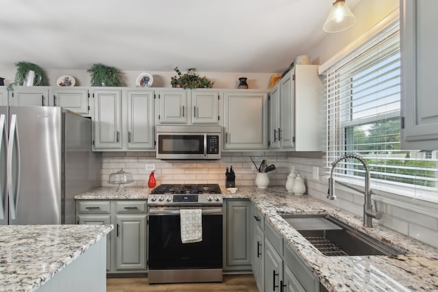 1034 Willoby Ln, Elgin, IL 60120 - kitchen with appliances with stainless steel finishes, a sink, decorative backsplash, and light stone countertops