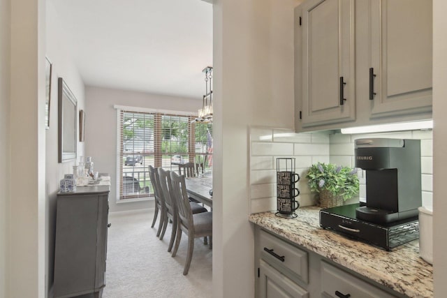 1034 Willoby Ln, Elgin, IL 60120 - bar featuring a chandelier, tasteful backsplash, and light carpet