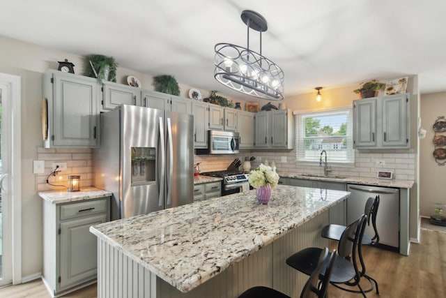 1034 Willoby Ln, Elgin, IL 60120 - kitchen featuring stainless steel appliances, a sink, light wood-style floors, and tasteful backsplash