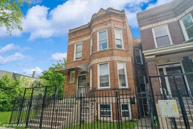 6151 S Marshfield Ave, Chicago, IL 60636 - view of property with brick siding, a fenced front yard, and a gate