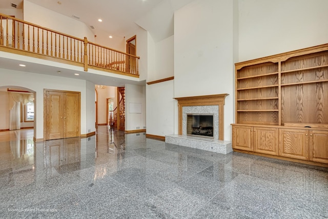 1773 W Whispering Ct, Addison, IL 60101 - unfurnished living room featuring arched walkways, granite tiled floors, a high ceiling, a high end fireplace, and recessed lighting