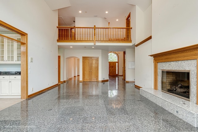 1773 W Whispering Ct, Addison, IL 60101 - unfurnished living room with a high ceiling, granite floors, arched walkways, and a premium fireplace
