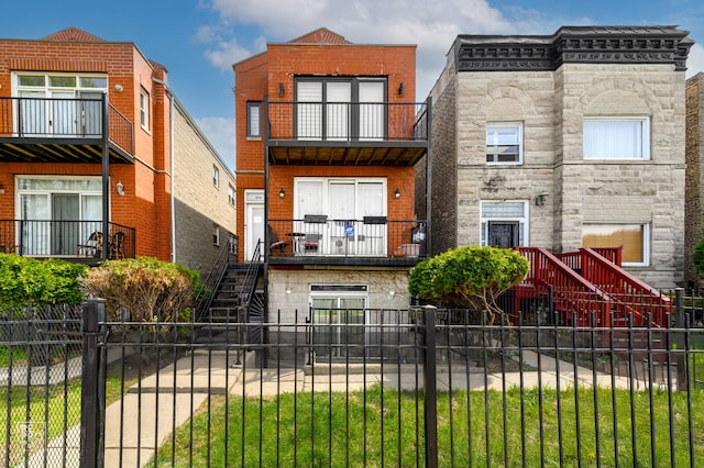 2711 W Congress Pkwy Unit 1, Chicago, IL 60612 - view of front of property featuring stairs, a fenced front yard, stone siding, and a balcony