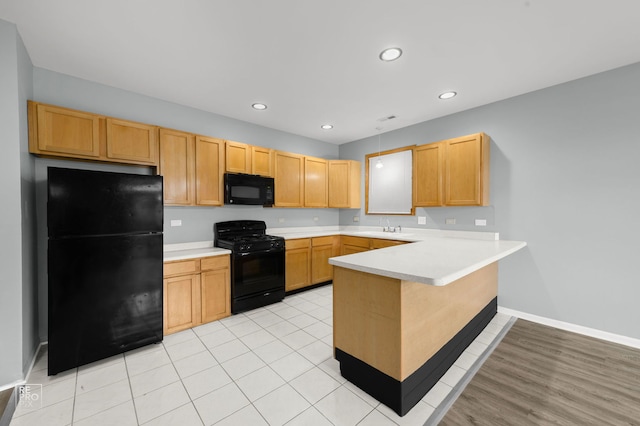 2711 W Congress Pkwy Unit 1, Chicago, IL 60612 - kitchen with black appliances, a peninsula, light countertops, a sink, and recessed lighting