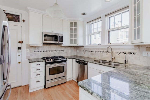 1929 Sherman Ave Unit 2E, Evanston, IL 60201 - kitchen with stainless steel appliances, a sink, white cabinetry, dark stone countertops, and glass insert cabinets