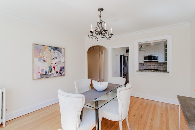 1929 Sherman Ave Unit 2E, Evanston, IL 60201 - dining room featuring arched walkways, wood finished floors, a chandelier, crown molding, and baseboards