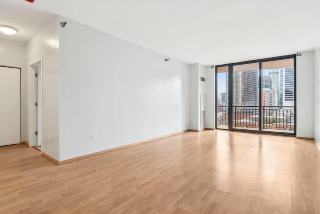 330 N Jefferson St Unit 1002, Chicago, IL 60661 - empty room with light wood-style flooring, a wall of windows, and a pendent fire sprinkler