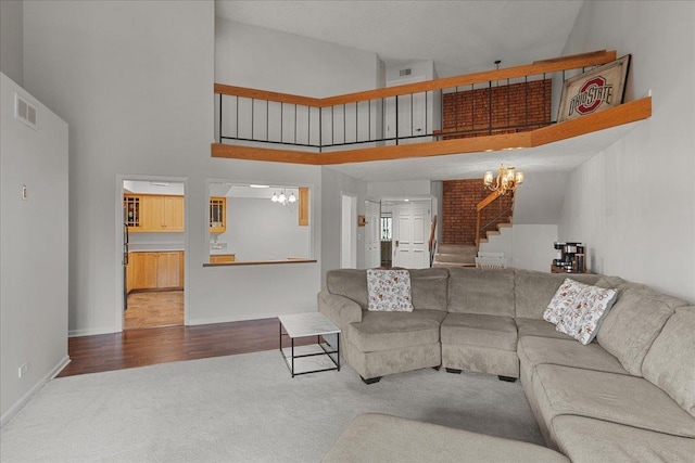 706 Waukegan Rd Unit 403C, Glenview, IL 60025 - carpeted living room featuring a chandelier, stairs, a towering ceiling, and baseboards