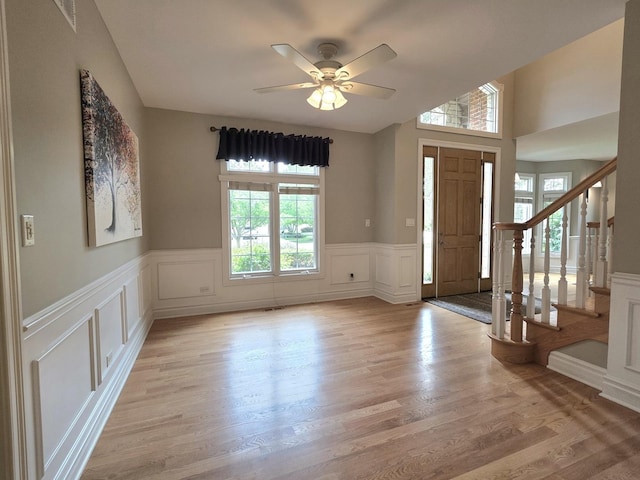 501 Siesta Dr, New Lenox, IL 60451 - foyer entrance featuring healthy amount of natural light, a decorative wall, a wainscoted wall, a ceiling fan, and light wood-style floors