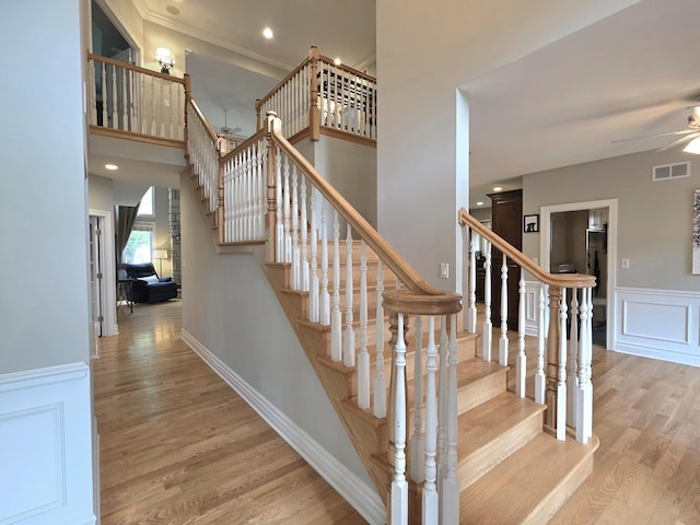 501 Siesta Dr, New Lenox, IL 60451 - stairs featuring wood finished floors, a ceiling fan, a decorative wall, wainscoting, and ornamental molding