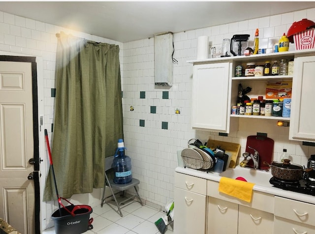 kitchen featuring tile walls, light tile patterned floors, light countertops, open shelves, and white cabinetry