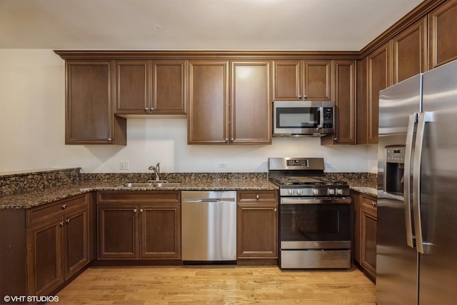6247 Lincoln Ave Unit 6-3, Morton Grove, IL 60053 - kitchen with appliances with stainless steel finishes, a sink, light wood-style floors, and dark stone counters