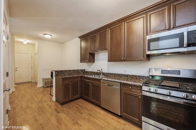 6247 Lincoln Ave Unit 6-3, Morton Grove, IL 60053 - kitchen featuring appliances with stainless steel finishes, a sink, light wood-style flooring, and dark stone countertops