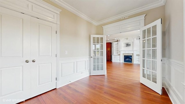 2540 W Diversey Ave Unit 404, Chicago, IL 60647 - corridor featuring french doors, ornamental molding, a decorative wall, wood finished floors, and wainscoting