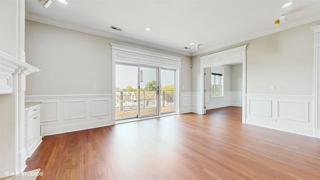 2540 W Diversey Ave Unit 404, Chicago, IL 60647 - unfurnished living room with crown molding, a wainscoted wall, wood finished floors, a decorative wall, and recessed lighting