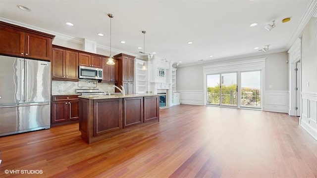 2540 W Diversey Ave Unit 404, Chicago, IL 60647 - kitchen with stainless steel appliances, a decorative wall, ornamental molding, wood finished floors, and a fireplace