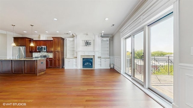 2540 W Diversey Ave Unit 404, Chicago, IL 60647 - unfurnished living room with ornamental molding, light wood-style floors, a fireplace with flush hearth, a wainscoted wall, and a decorative wall
