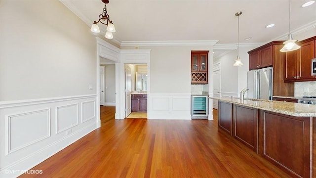 2540 W Diversey Ave Unit 404, Chicago, IL 60647 - kitchen with appliances with stainless steel finishes, wine cooler, ornamental molding, dark wood-type flooring, and a decorative wall