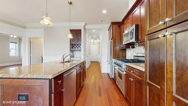 2540 W Diversey Ave Unit 404, Chicago, IL 60647 - kitchen with appliances with stainless steel finishes, light wood-style floors, ornamental molding, a kitchen island with sink, and a sink