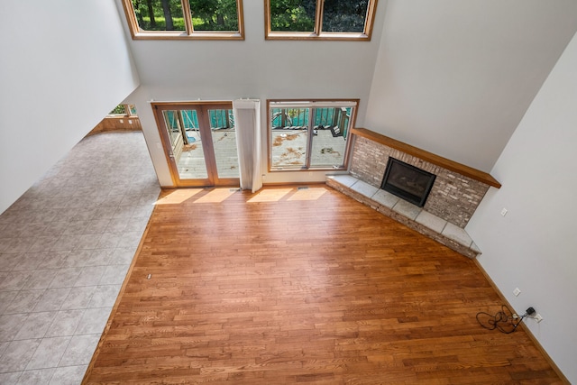 2946 County Road 800 E, Dewey, IL 61840 - unfurnished living room featuring plenty of natural light, a fireplace, wood finished floors, a towering ceiling, and baseboards