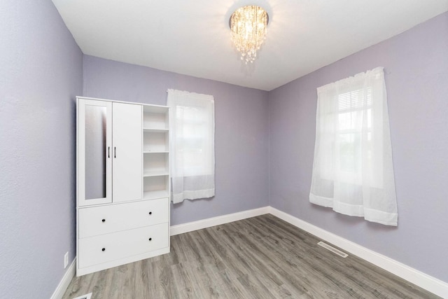 2725 2100n Rd, Minonk, IL 61760 - unfurnished bedroom featuring wood finished floors, baseboards, and a chandelier