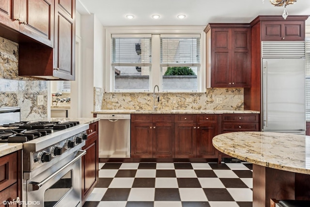 1320 N State Pkwy Unit 2A, Chicago, IL 60610 - kitchen with premium appliances, dark floors, reddish brown cabinets, backsplash, and recessed lighting