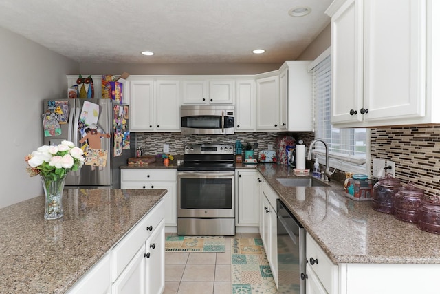 2738 Wharton Way, Normal, IL 61761 - kitchen featuring stainless steel appliances, a sink, white cabinetry, tasteful backsplash, and light tile patterned floors