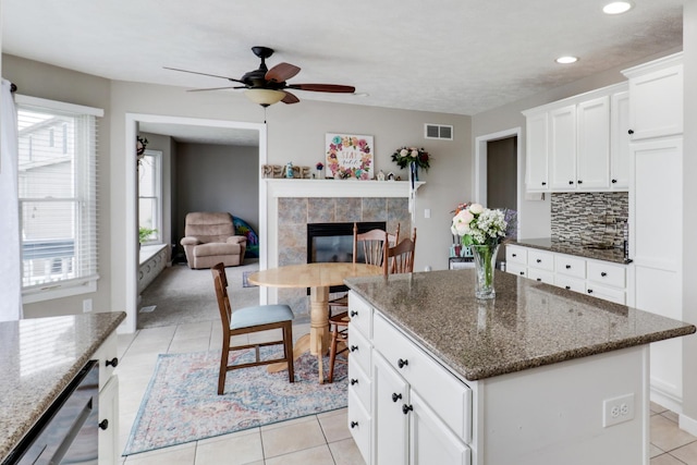 2738 Wharton Way, Normal, IL 61761 - kitchen with a tile fireplace, dishwasher, tasteful backsplash, light tile patterned floors, and a kitchen island