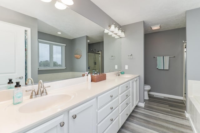 2738 Wharton Way, Normal, IL 61761 - bathroom featuring double vanity, toilet, a shower with shower door, a tub, and wood finished floors