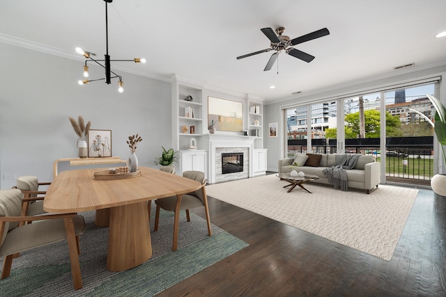 825 N Hudson Ave Unit 1B, Chicago, IL 60610 - dining space featuring ornamental molding, a glass covered fireplace, dark wood finished floors, a ceiling fan, and built in shelves