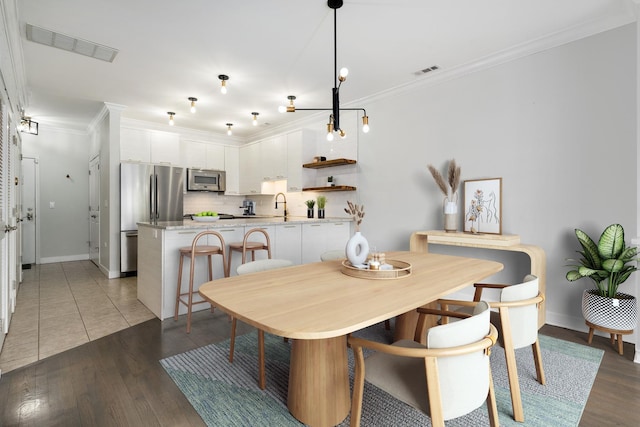 825 N Hudson Ave Unit 1B, Chicago, IL 60610 - dining area with ornamental molding, light wood finished floors, baseboards, and a chandelier
