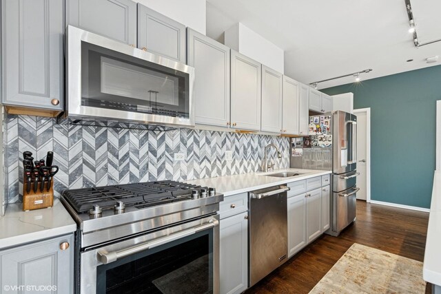 849 N Franklin St Unit 618, Chicago, IL 60610 - kitchen with appliances with stainless steel finishes, a sink, track lighting, dark wood finished floors, and backsplash