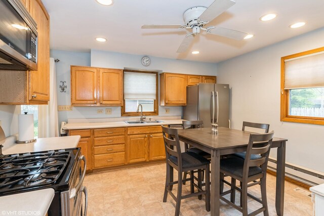 412 Midway Dr, Mundelein, IL 60060 - kitchen featuring stainless steel appliances, a sink, a baseboard heating unit, a ceiling fan, and light countertops