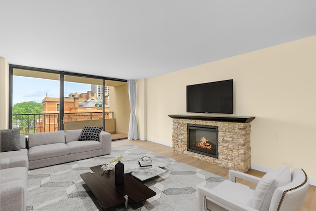 1450 N Astor St Unit 7D, Chicago, IL 60610 - living room with wood finished floors, a stone fireplace, floor to ceiling windows, and baseboards