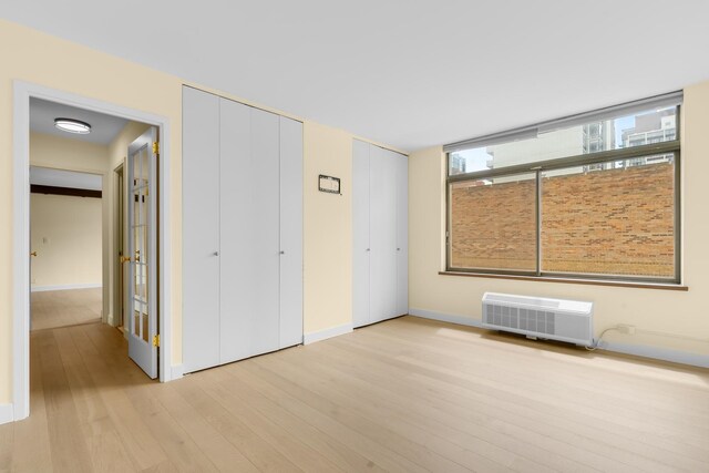 1450 N Astor St Unit 7D, Chicago, IL 60610 - unfurnished bedroom featuring light wood-type flooring, multiple closets, and baseboards