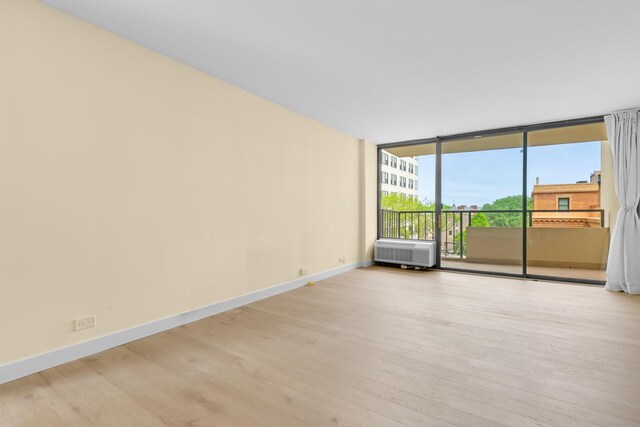 1450 N Astor St Unit 7D, Chicago, IL 60610 - unfurnished room with wood finished floors, baseboards, and a wall of windows