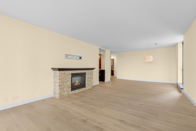 1450 N Astor St Unit 7D, Chicago, IL 60610 - unfurnished living room with light wood-style floors, a stone fireplace, and baseboards