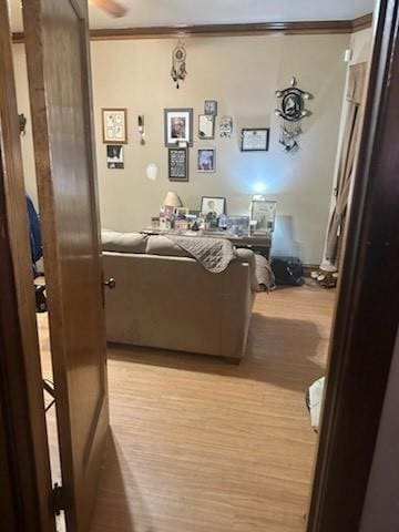 living area with light wood-style flooring and crown molding