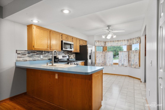 916 Shady Ln, Aurora, IL 60506 - kitchen featuring stainless steel appliances, a peninsula, a ceiling fan, decorative backsplash, and a sink