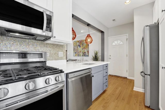 1737 W Balmoral Ave Unit 1A, Chicago, IL 60640 - kitchen with stainless steel appliances, decorative backsplash, light wood-type flooring, a sink, and light countertops