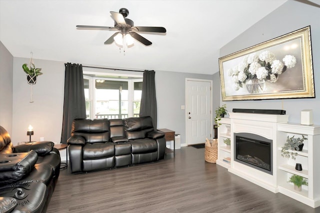 23246 S Malibu Dr, Manhattan, IL 60442 - living room with lofted ceiling, a ceiling fan, dark wood-style floors, a glass covered fireplace, and baseboards