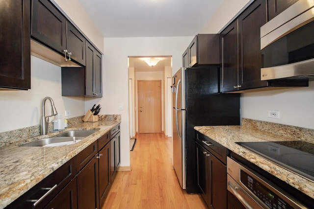 3150 W Bryn Mawr Ave Unit 301, Chicago, IL 60659 - kitchen featuring appliances with stainless steel finishes, a sink, light wood-style floors, light stone counters, and dark brown cabinetry