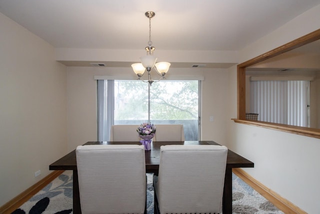 3150 W Bryn Mawr Ave Unit 301, Chicago, IL 60659 - dining room featuring a chandelier, baseboards, and wood finished floors