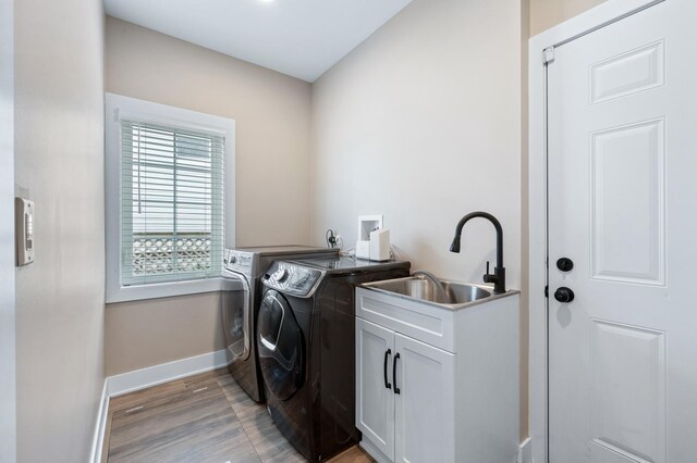 8029 98th St, Palos Hills, IL 60465 - laundry room with washer and dryer, cabinet space, baseboards, and light wood-style floors