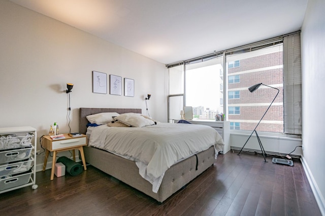 bedroom with dark wood-style flooring and baseboards