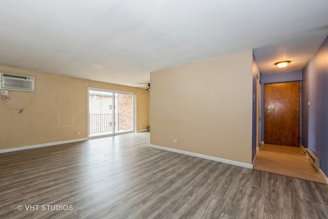 4137 W 97th Pl Unit 311, Oak Lawn, IL 60453 - spare room with a wall unit AC, wood finished floors, baseboards, and a baseboard radiator