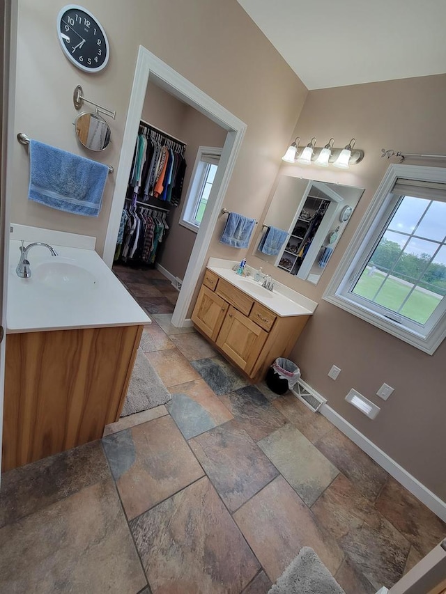 7648 N Indian Ridge Rd, East Dubuque, IL 61025 - bathroom featuring stone tile flooring, baseboards, vanity, and a spacious closet