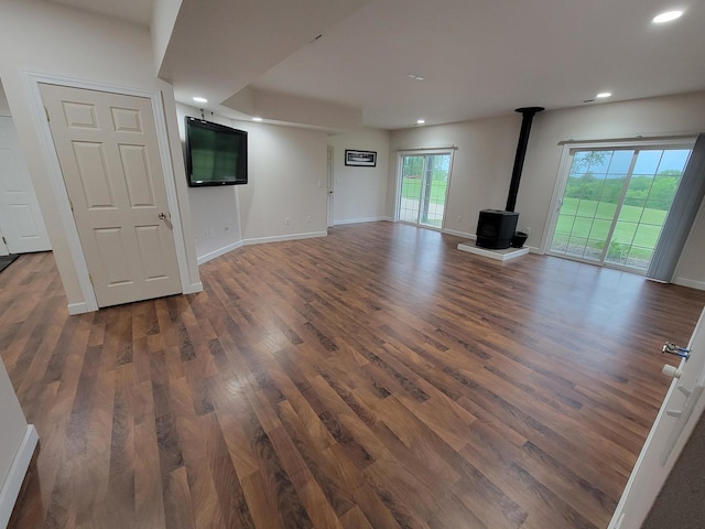 7648 N Indian Ridge Rd, East Dubuque, IL 61025 - unfurnished living room with a wood stove, recessed lighting, wood finished floors, and baseboards