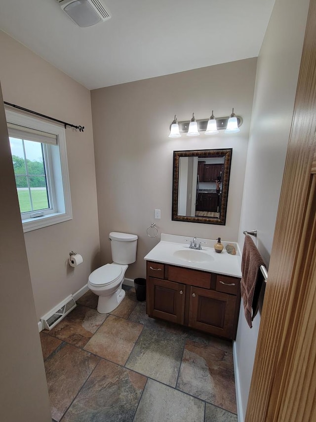 7648 N Indian Ridge Rd, East Dubuque, IL 61025 - bathroom with stone tile flooring, baseboards, toilet, and vanity