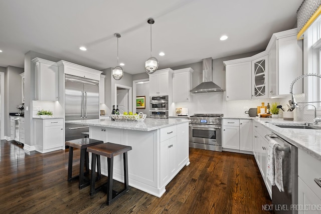 4336 Winterberry Ave, Naperville, IL 60564 - kitchen featuring wall chimney exhaust hood, premium appliances, white cabinets, a kitchen island, and backsplash